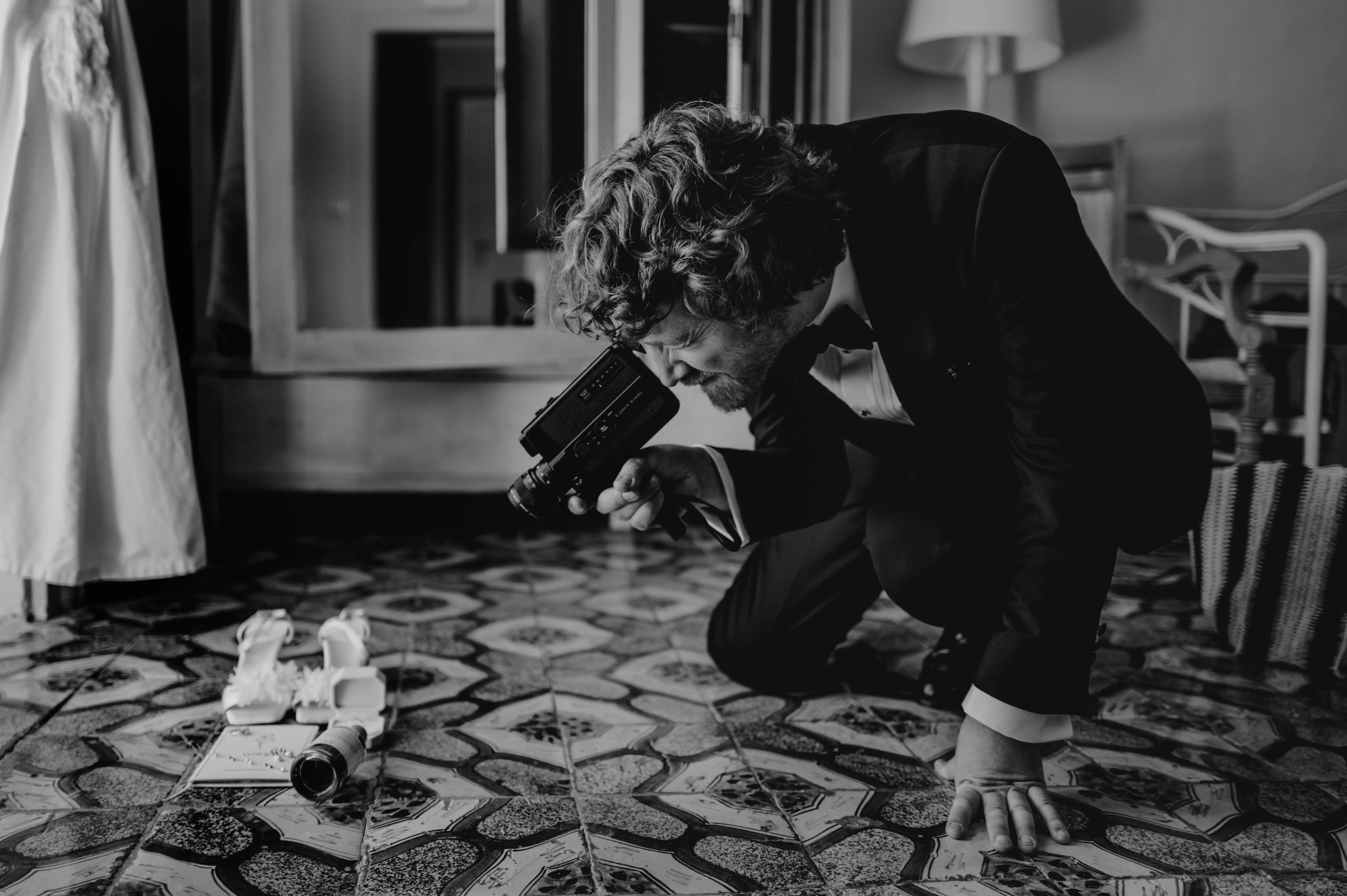 Editorial black and white wedding photography moment with filmmaker documenting bridal details